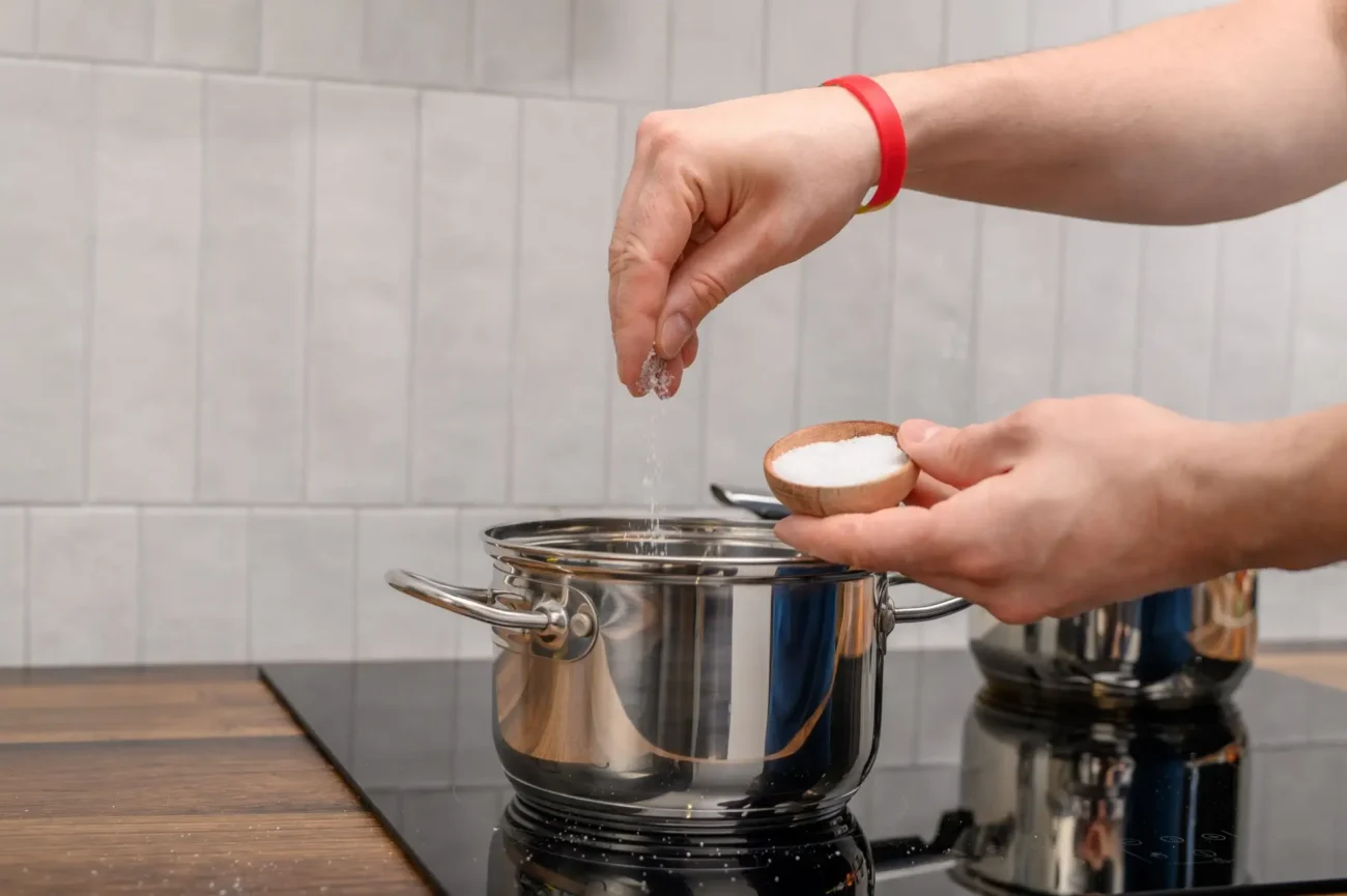 muž solí vodu v hrnci