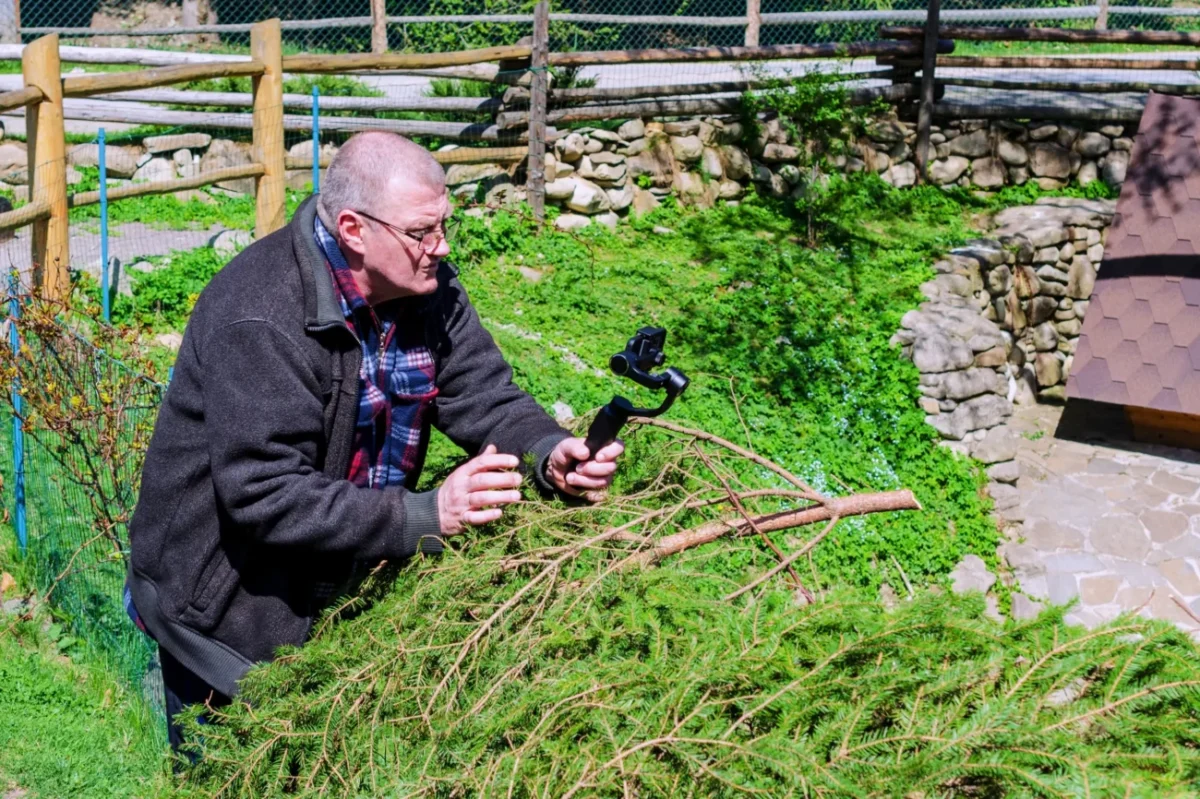 muž stojí před kamerou v trávě