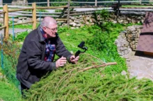 muž stojí před kamerou v trávě