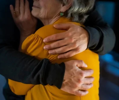 Muž drží starší ženu v objetí.