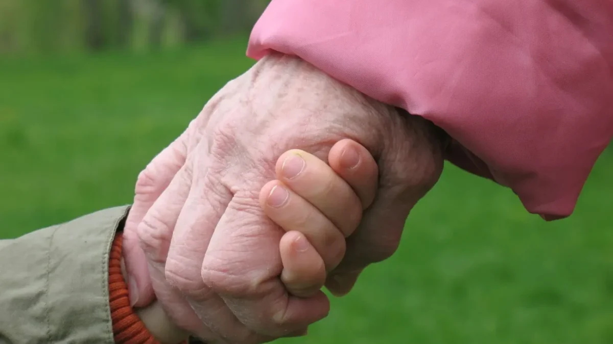 babička drží za ruku malé dítě