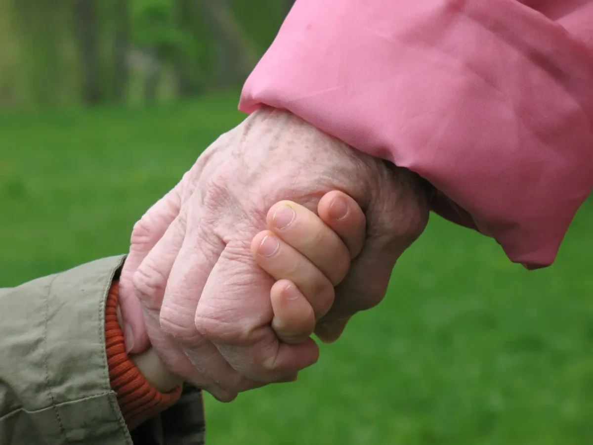 babička drží za ruku malé dítě