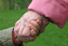 babička drží za ruku malé dítě