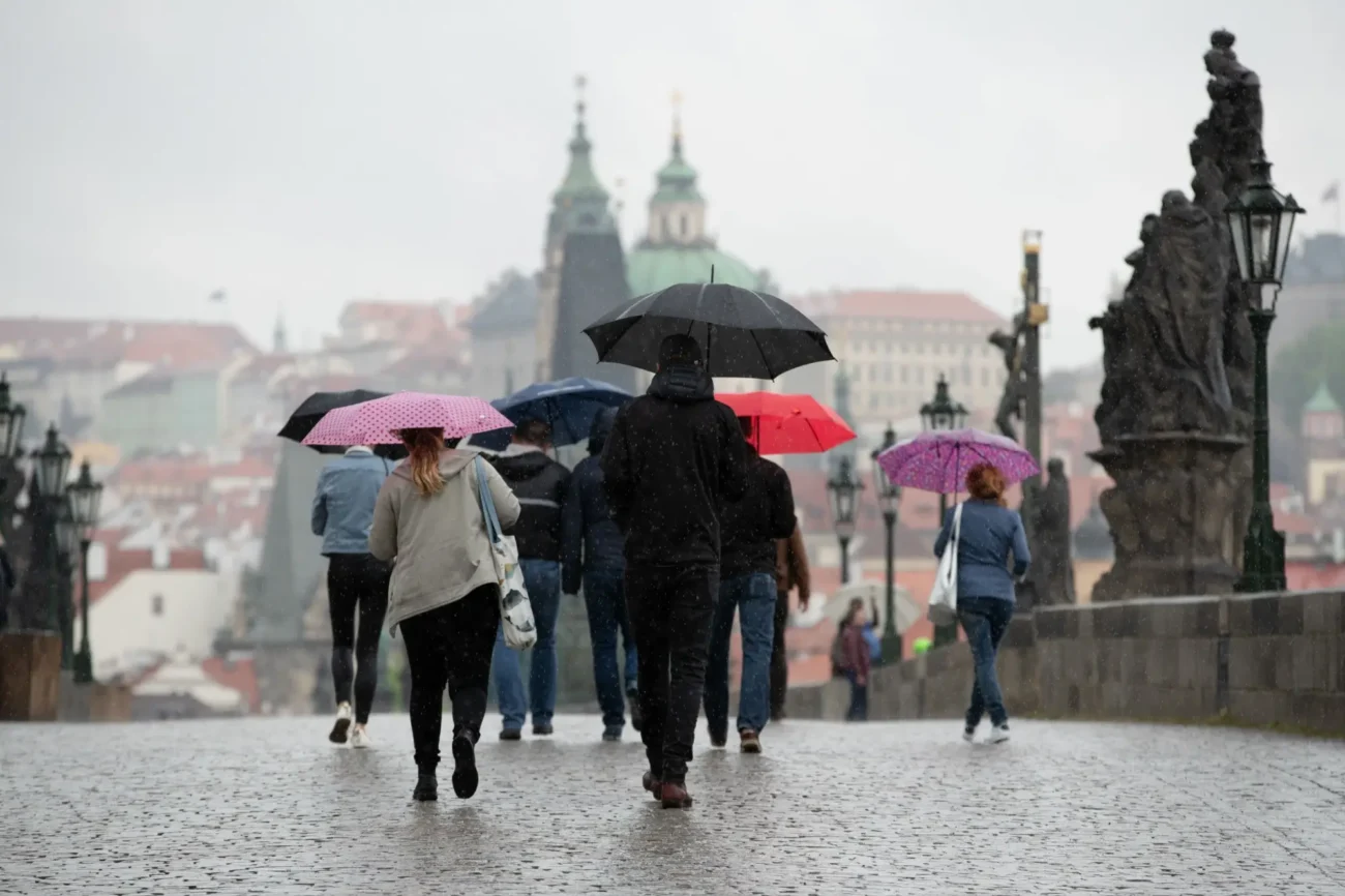 lidé v Praze za deštivého počasí s deštníky