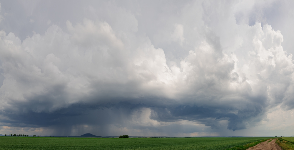 Temné bouřkové mraky nad krajinou (pole, polní cesta)