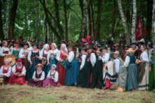 Poláci stojící vedle sebe v krojích.