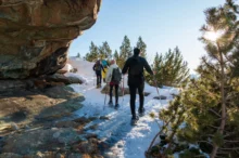 Lidé se procházejí po sněhem pokrytých horách.