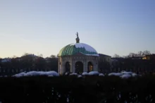 Mnichov, Hofgarten: zimní scéna slavné Zahrady u dvora (Schlossgarten) a Dianina chrámu (Dianatempel) v centru města, s bílým sněhem a modrou oblohou