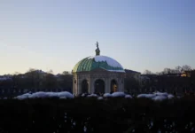 Mnichov, Hofgarten: zimní scéna slavné Zahrady u dvora (Schlossgarten) a Dianina chrámu (Dianatempel) v centru města, s bílým sněhem a modrou oblohou