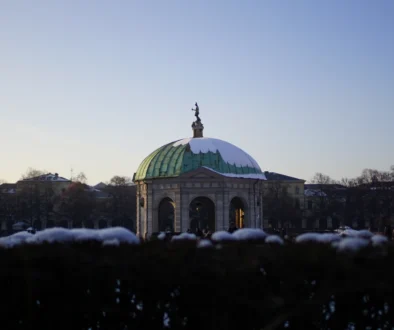 Mnichov, Hofgarten: zimní scéna slavné Zahrady u dvora (Schlossgarten) a Dianina chrámu (Dianatempel) v centru města, s bílým sněhem a modrou oblohou