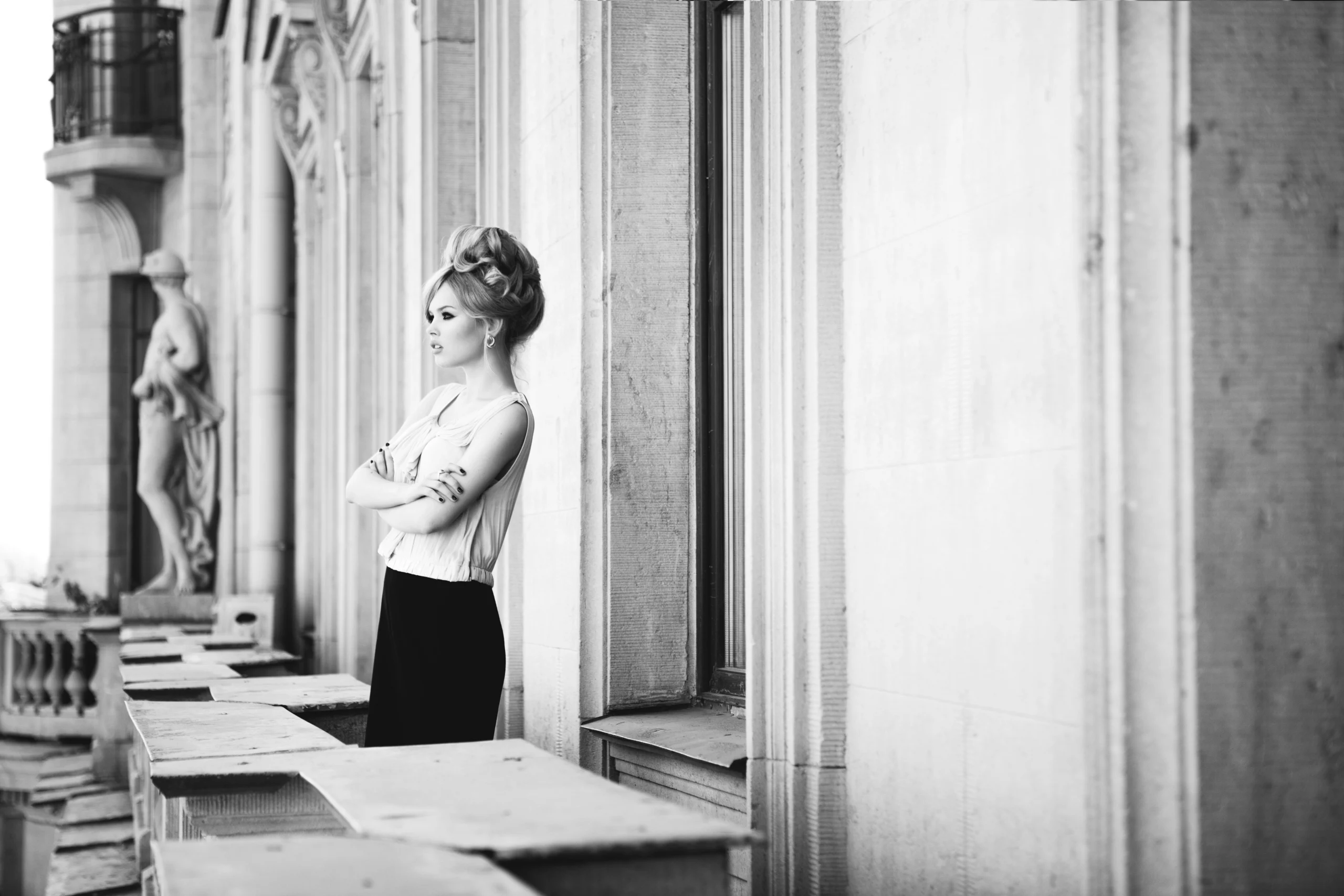 Portrét krásné blondýnky na balkoně. Hledí do dálky. Ve stylu Brigitte Bardot. Černobílé foto