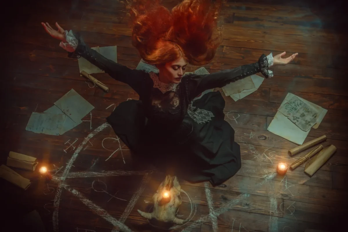 Žena sedí na zemi a věnuje se magii.