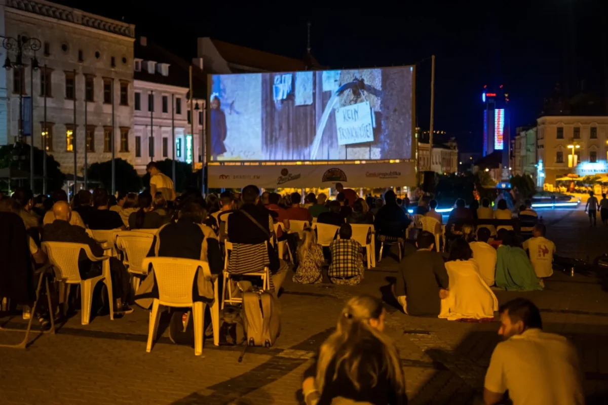 Slováci sedí na náměstí a užívají si letního kina.
