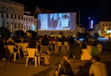 Slováci sedí na náměstí a užívají si letního kina.