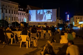 Slováci sedí na náměstí a užívají si letního kina.