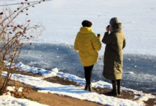 dvě ženy v teplém oblečení pijí kávu v zimní krajině