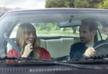 Margot Robbie a Colin Farrell jedoucí v autě ve filmu Velká odvážná nádherná cesta.