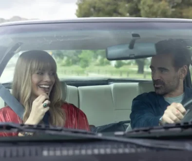 Margot Robbie a Colin Farrell jedoucí v autě ve filmu Velká odvážná nádherná cesta.