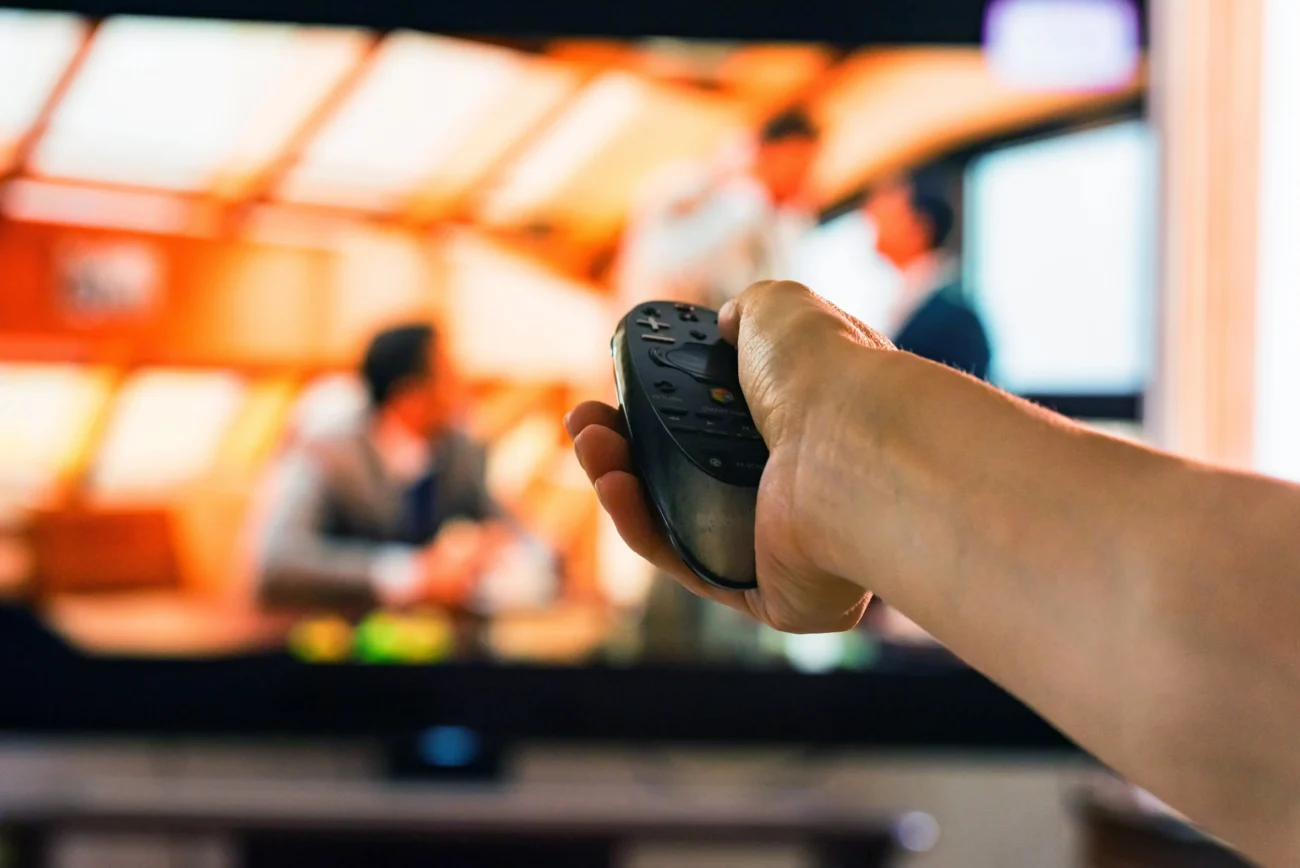 shutterstock_1241317210-2 | TVGURU.cz Člověk ovladačem míří na televizi.