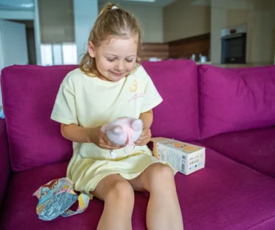 Holčička sedí na gauči a má na klíně Labubu.
