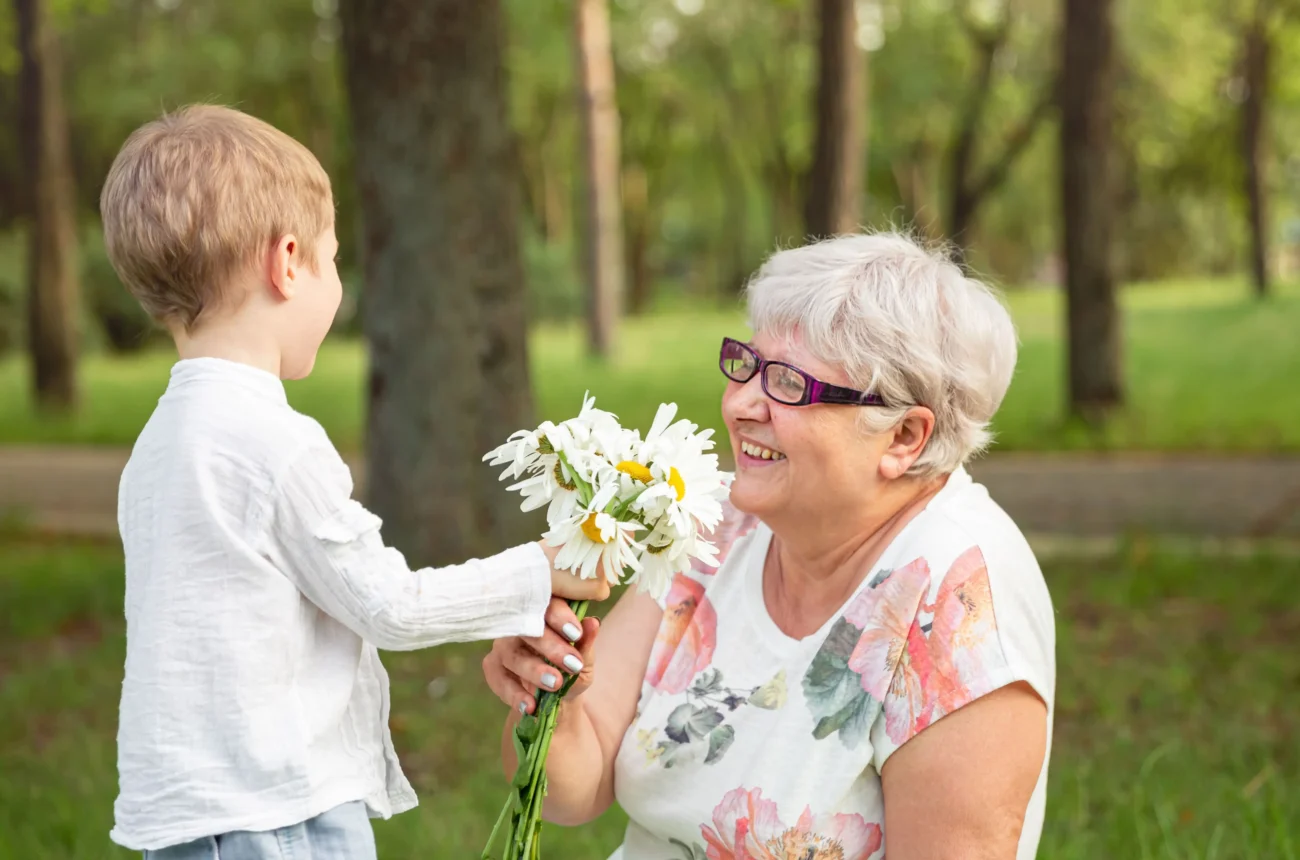 seniorka s dítětem si předávají květinu