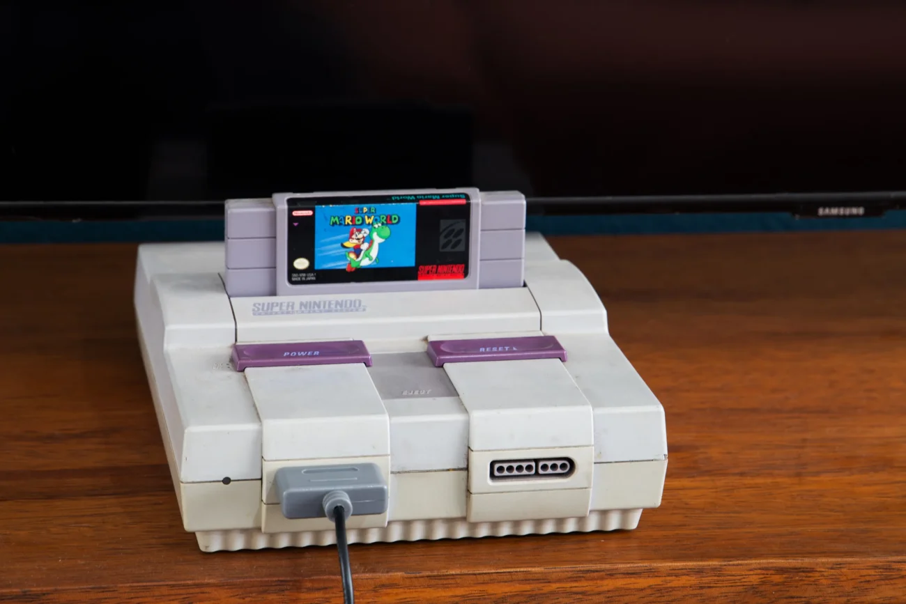 shutterstock_1960831192-2 | TVGURU.cz Na stole jep položená herní konzole Super Nintendo.
