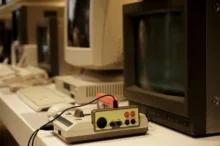 Před starou televizí leží retro herní konzole.