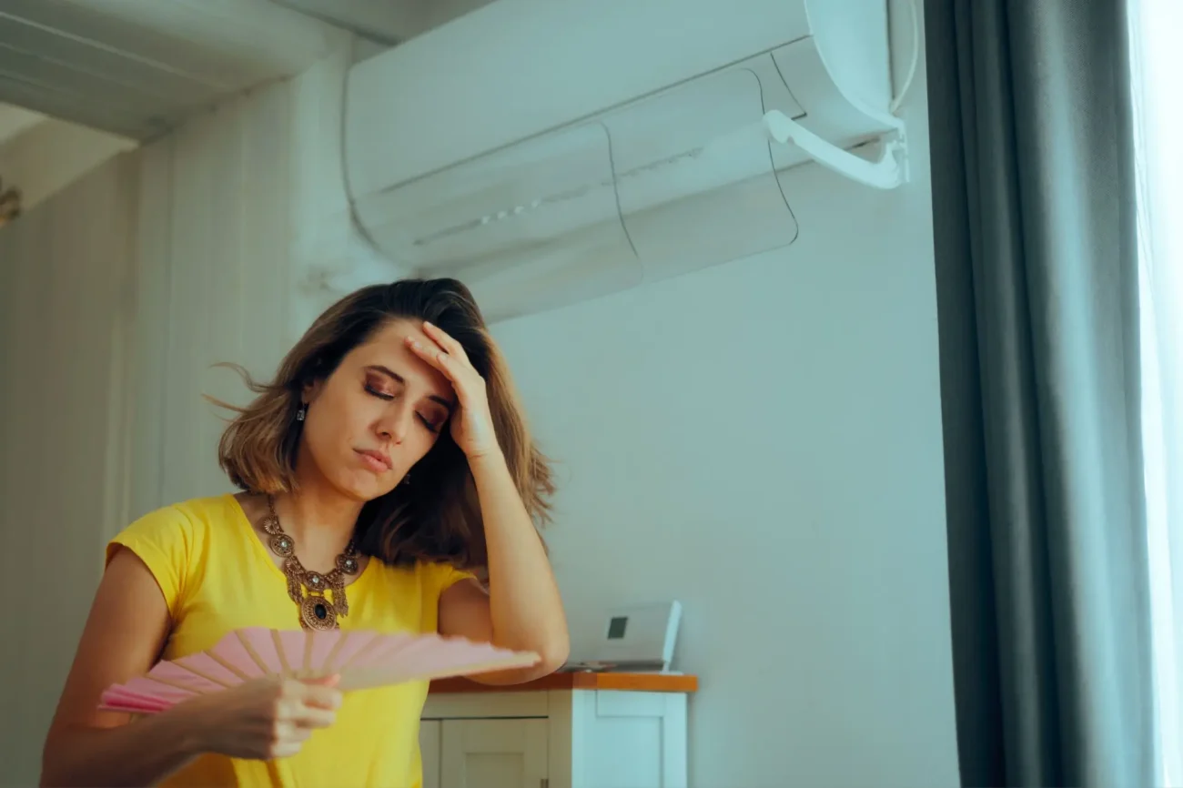 žena ve stresu, drží se za hlavu, v ruce má vějíř