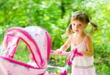 Holčička s růžovým kočárkem.