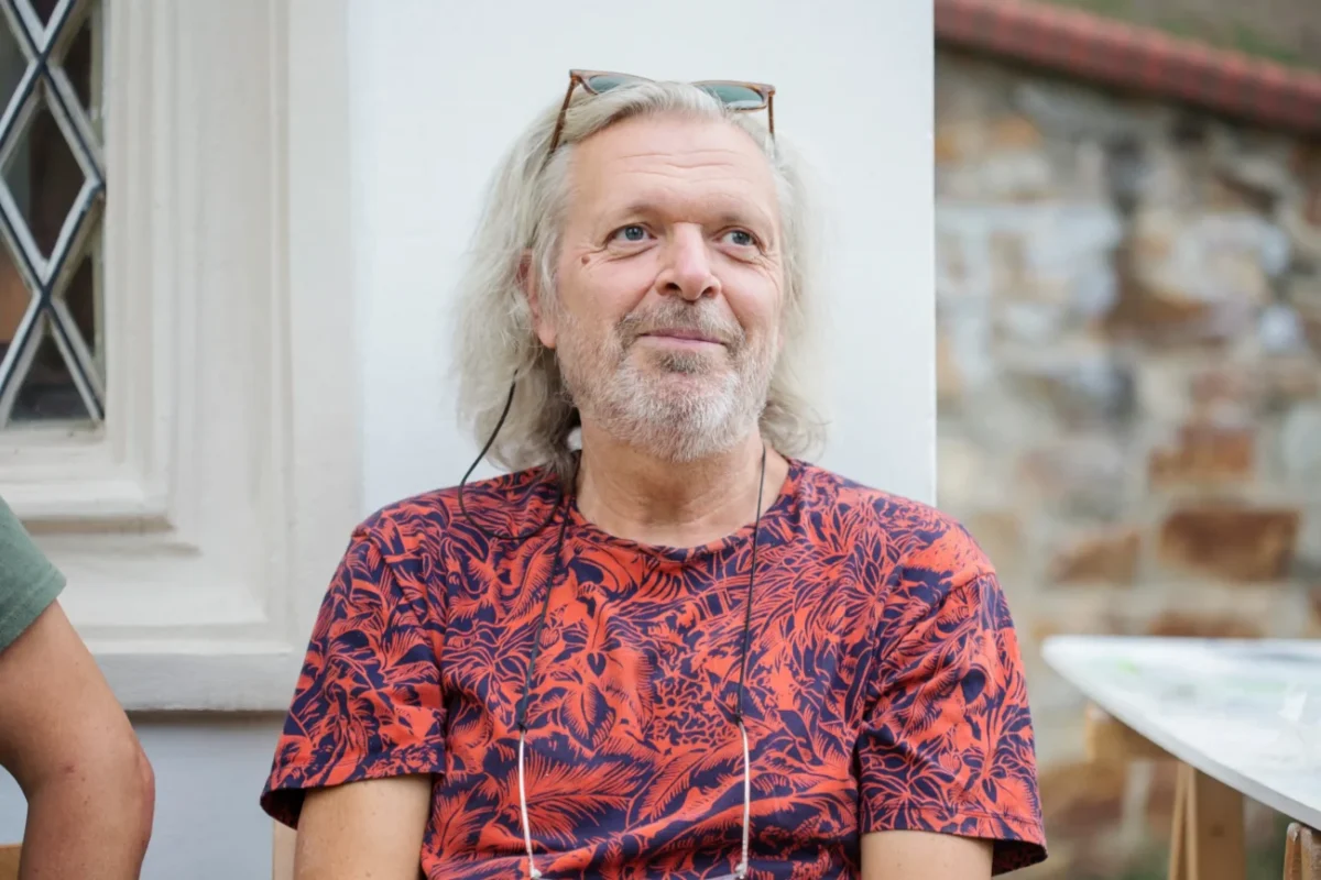 Muž sedí a usmívá se