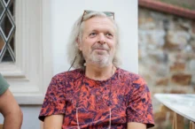 Muž sedí a usmívá se