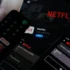 ovladač v ruce pouští netflix