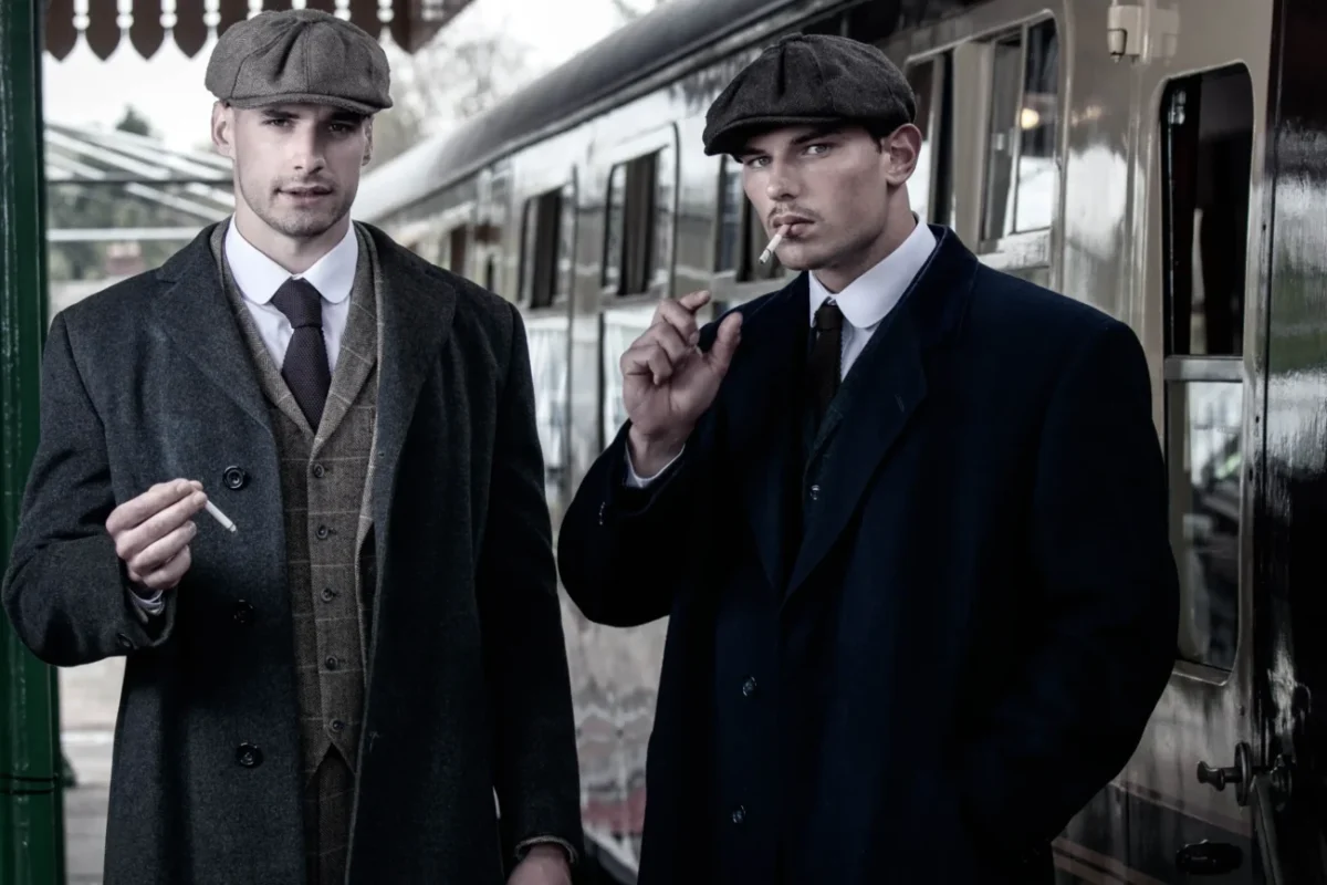 Dva muži stojí na vlakovém nástupišti.