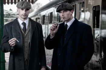 Dva muži stojí na vlakovém nástupišti.