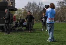 muž s kamerou na trávě