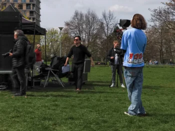 muž s kamerou na trávě