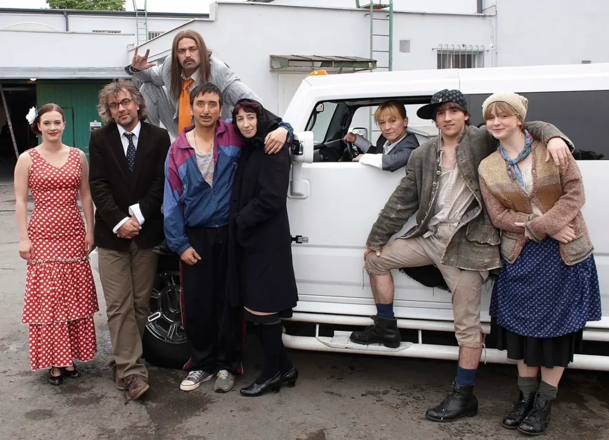 Herci z Comebacku společně stojí u auta.