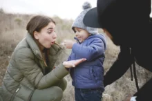 Žena je skloněná u chlapečka.