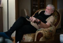 Starý muž sedí v křesle a dívá se na TV.