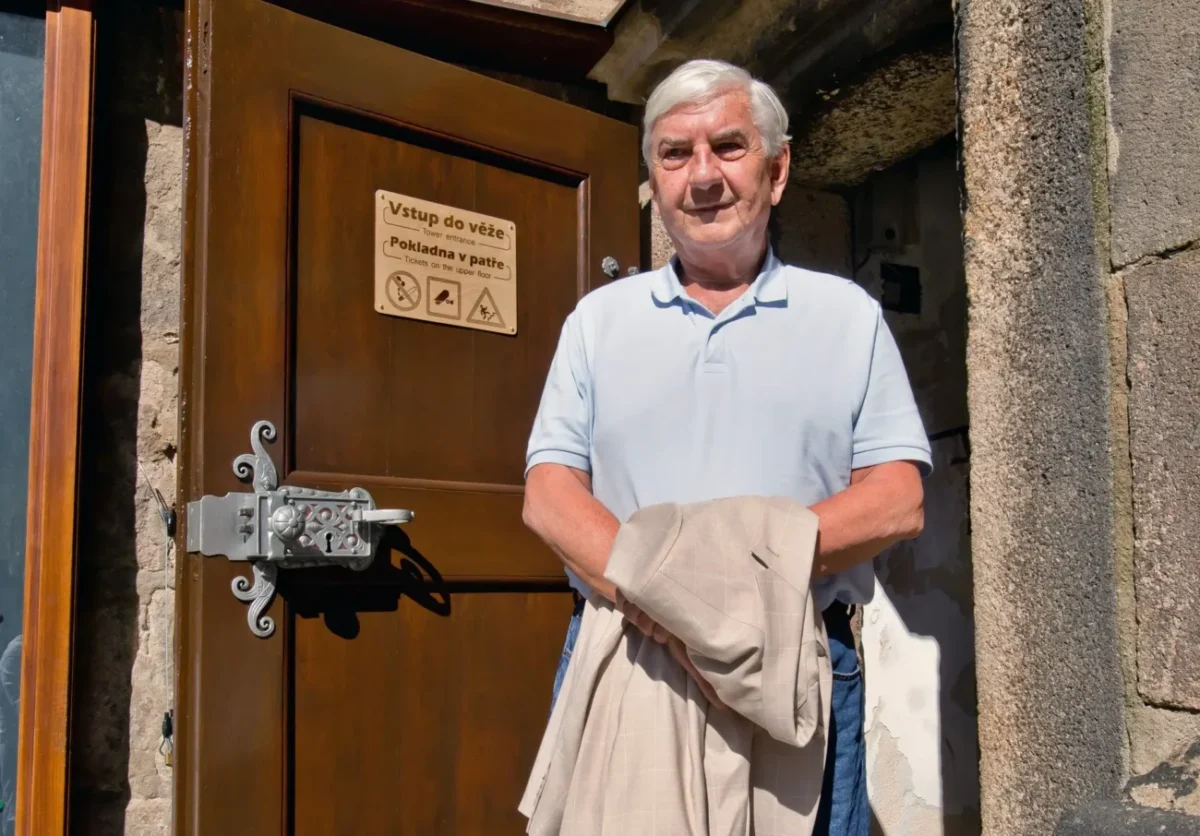 Miroslav Donutil stojí u dveří vedoucích do věže.