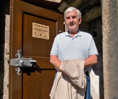 Miroslav Donutil stojí u dveří vedoucích do věže.