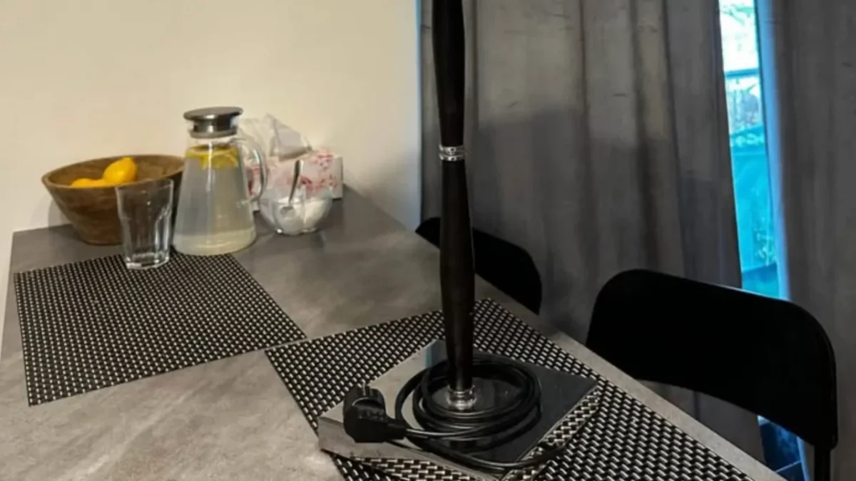 stůl v kuchyni, leží na něm lampa s elektrickou zásuvkou
