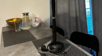 stůl v kuchyni, leží na něm lampa s elektrickou zásuvkou