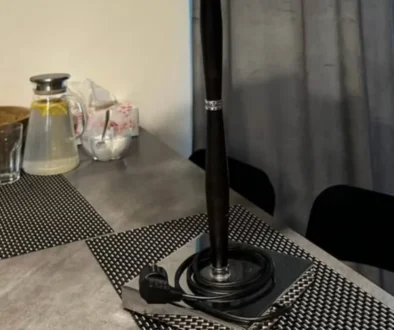 stůl v kuchyni, leží na něm lampa s elektrickou zásuvkou