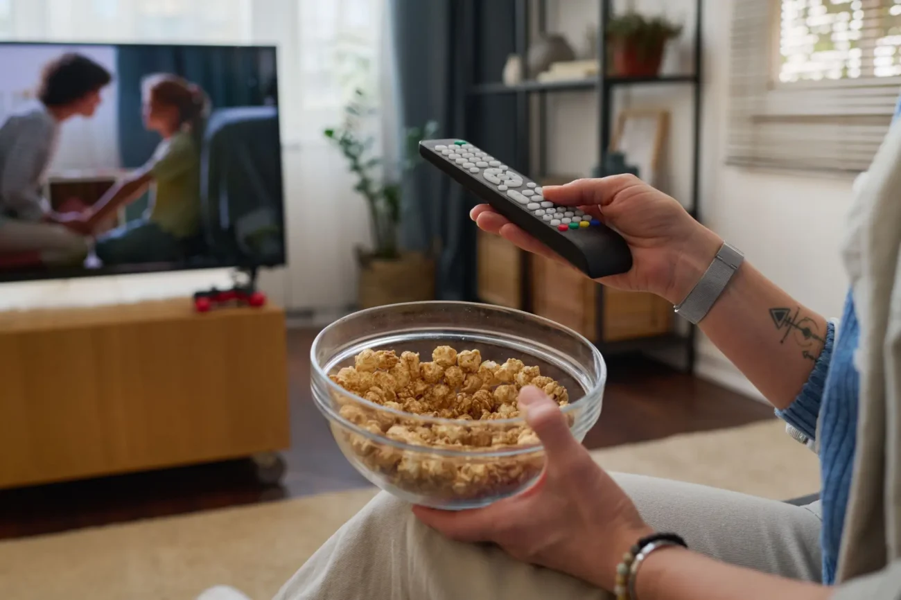 Shutterstock_2404760049 | TVGURU.cz žena s popcornem sleduje televizi