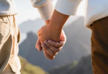 pár se drží za ruce kdesi v přírodě