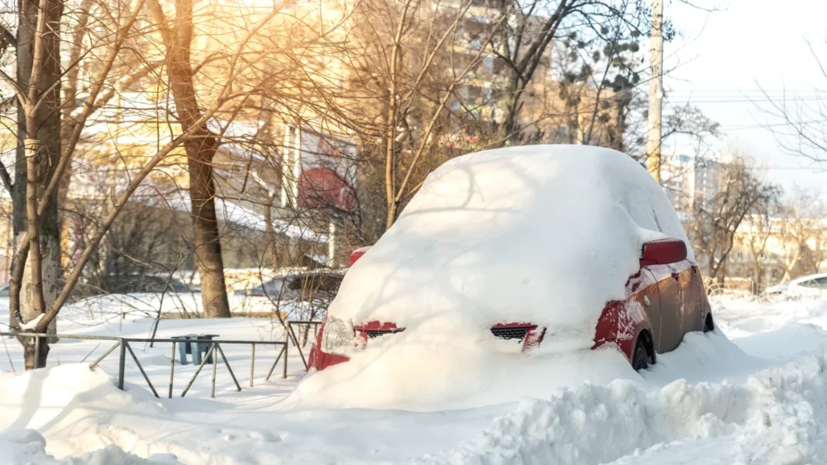 shutterstock_2238680237 zasněžené osobní auto v závěji, zimní den v přírodě
