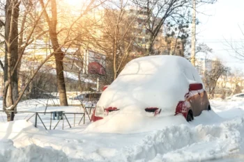 zasněžené osobní auto v závěji, zimní den v přírodě