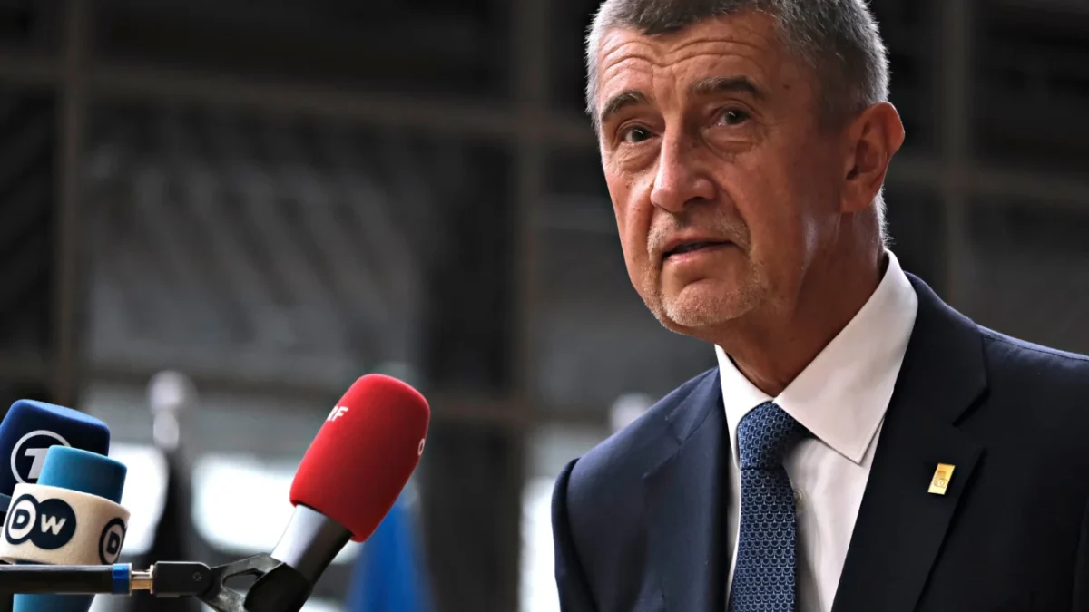 Andrej Babiš stojí u mikrofonu.