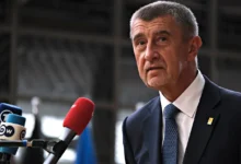 Andrej Babiš stojí u mikrofonu.